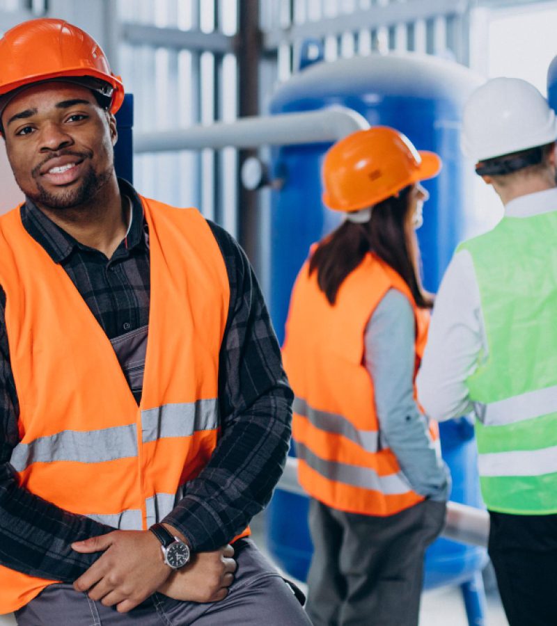 three-factory-workers-safety-hats-discussing-manufacture-plan